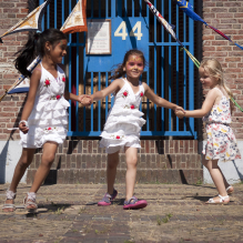 Three girls holding hands and dancing in Moerwijk, The Hague