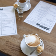 A table photographed from above with menus and coffees