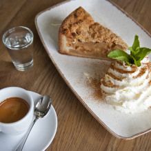 Photo taken from above of an espresso and apple pie with whipped cream