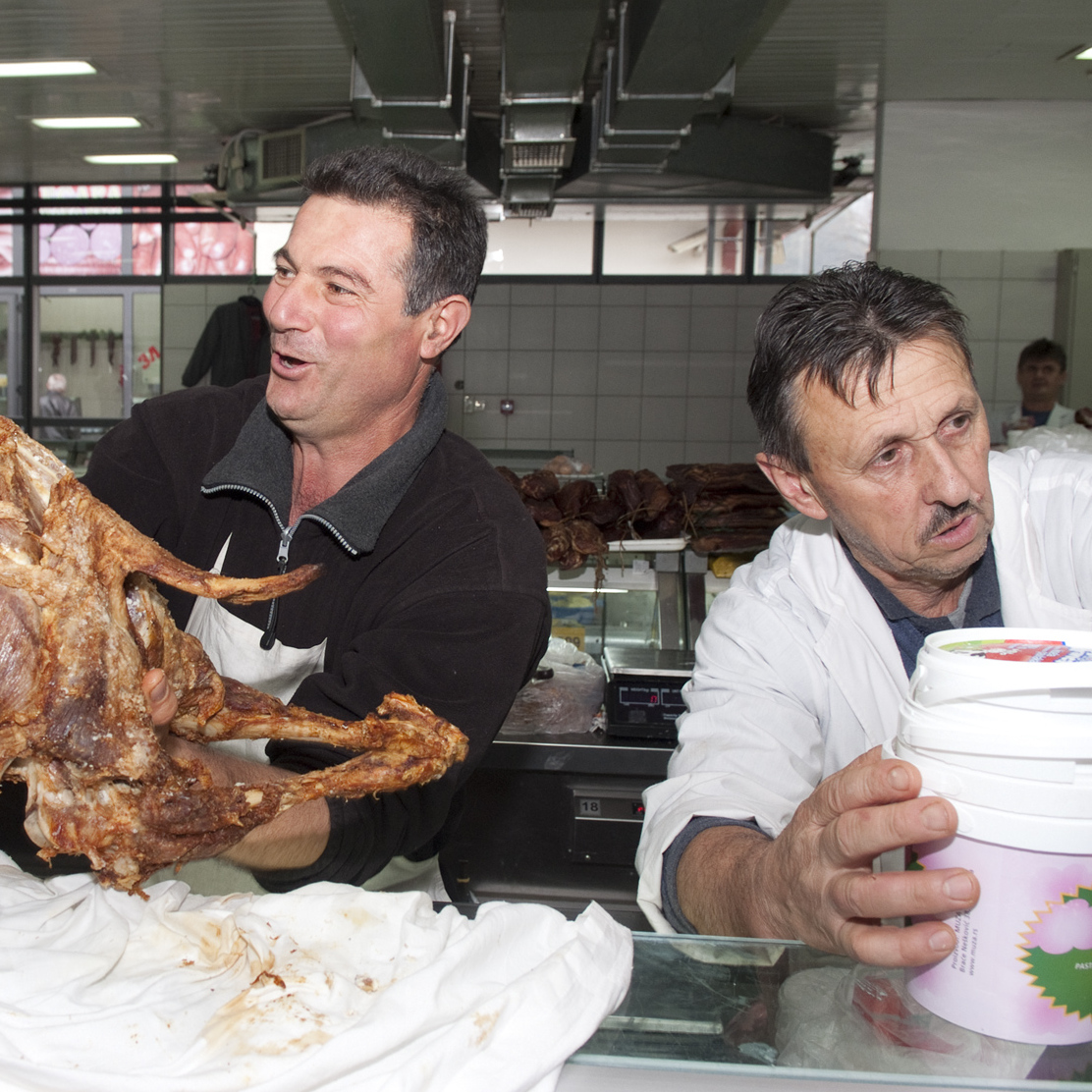 Two butchers showing meat at the market in Belgrade
